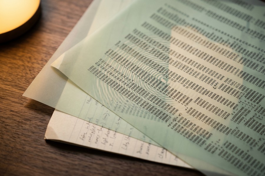 Self-employed worker reviewing Schedule C tax form and credit worksheets at a laptop
