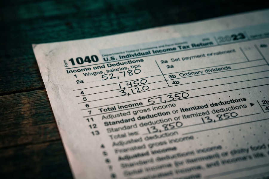 Freelancer reviewing Schedule C tax forms at a home office desk