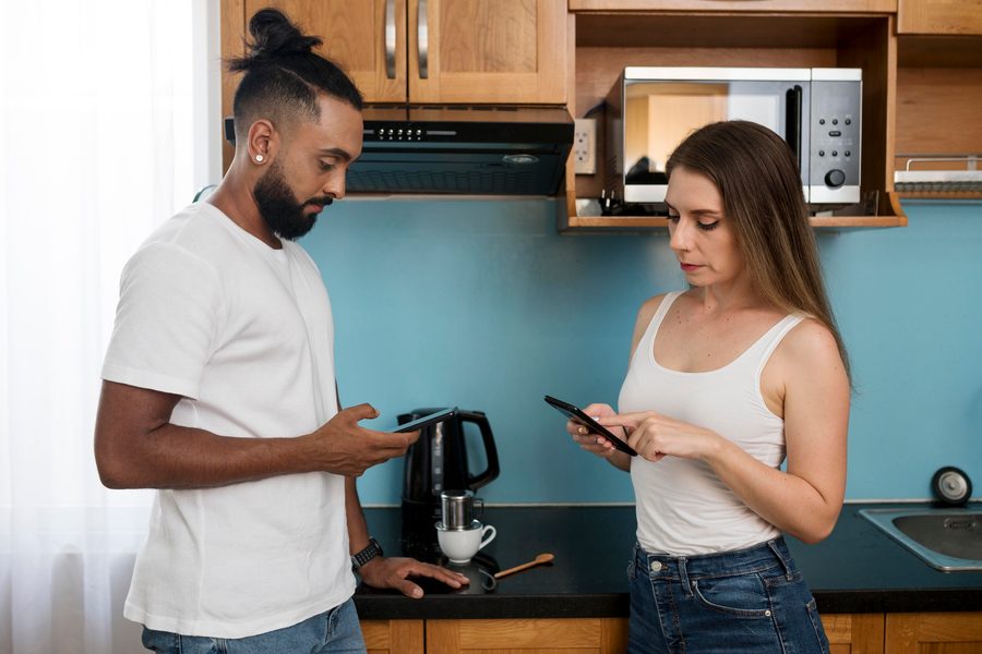 A renter inspecting a stainless-steel refrigerator being delivered to a furnished apartment.