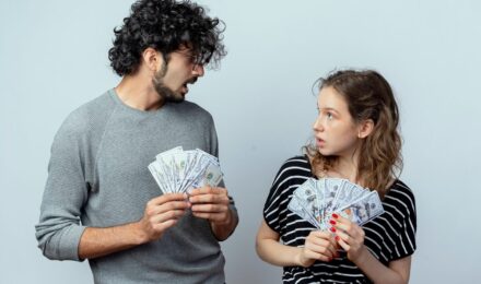 Couple reviewing budget together on tablet with financial documents