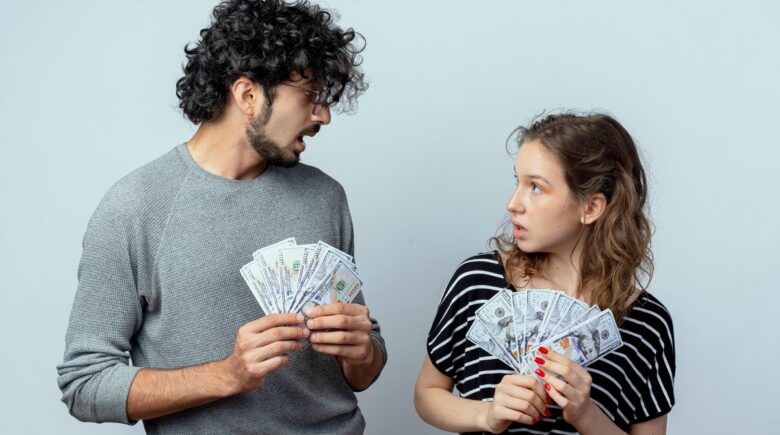 Couple reviewing budget together on tablet with financial documents