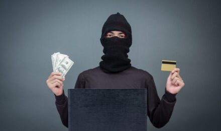 Person reviewing financial statements and security alerts on a laptop to protect against fraud