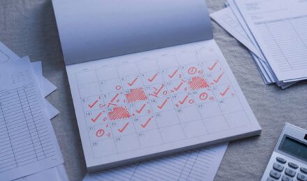 Freelancer reviewing monthly income fluctuations and building a financial buffer on laptop