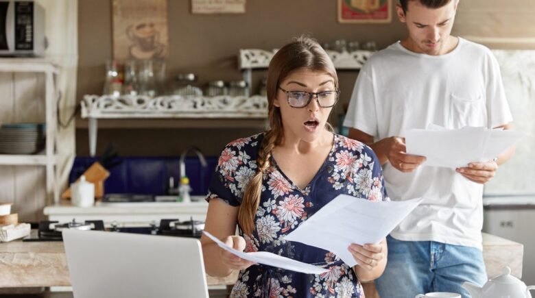 Tax documents and calculator on desk with homeowner reviewing deductions