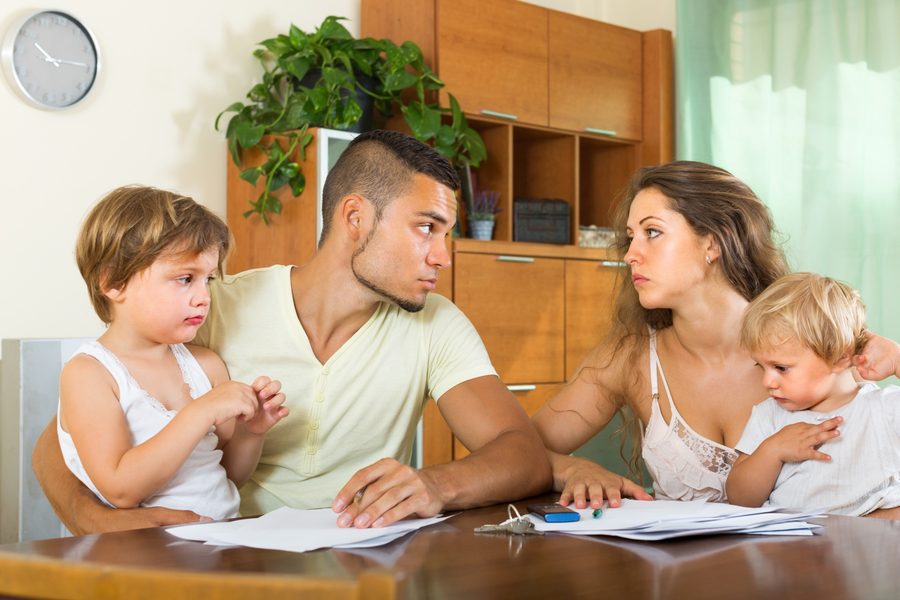 Tax professional reviewing a family's tax return documents with a laptop open