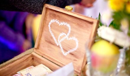 Couple planning wedding budget with calculator and notebook