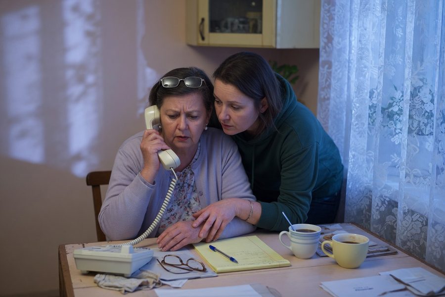 A retiree at a computer, setting up a my Social Security account on ssa.gov, with a family member nearby.