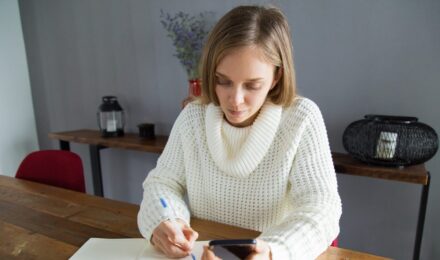 A person reviewing their bank statements, showing a checking account and savings account balance comparison