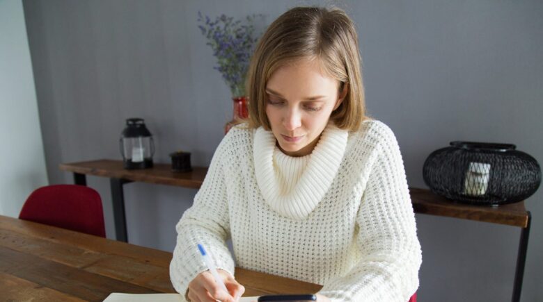 A person reviewing their bank statements, showing a checking account and savings account balance comparison